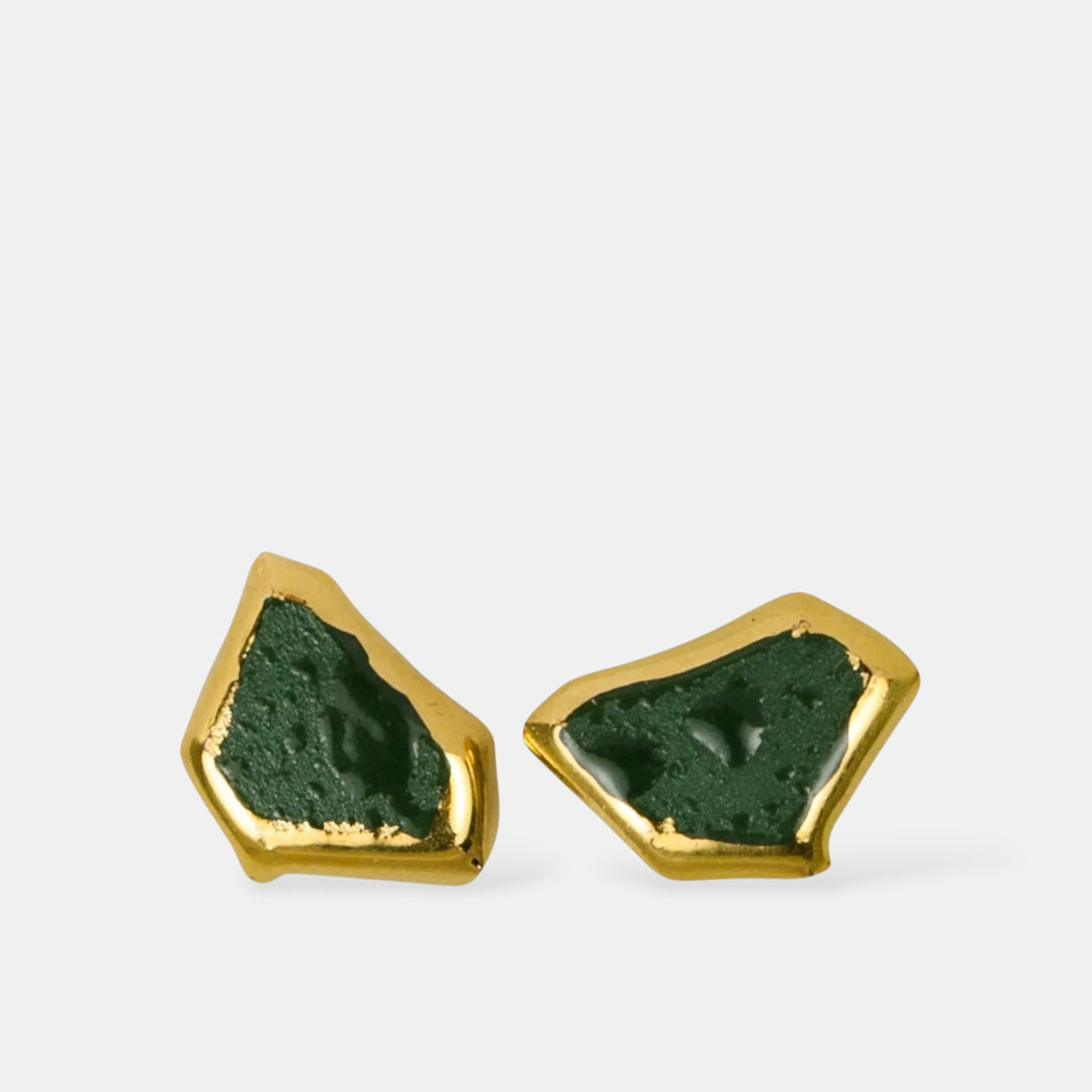 Pair of earrings with green porcelain earrings and gold frame on a white background