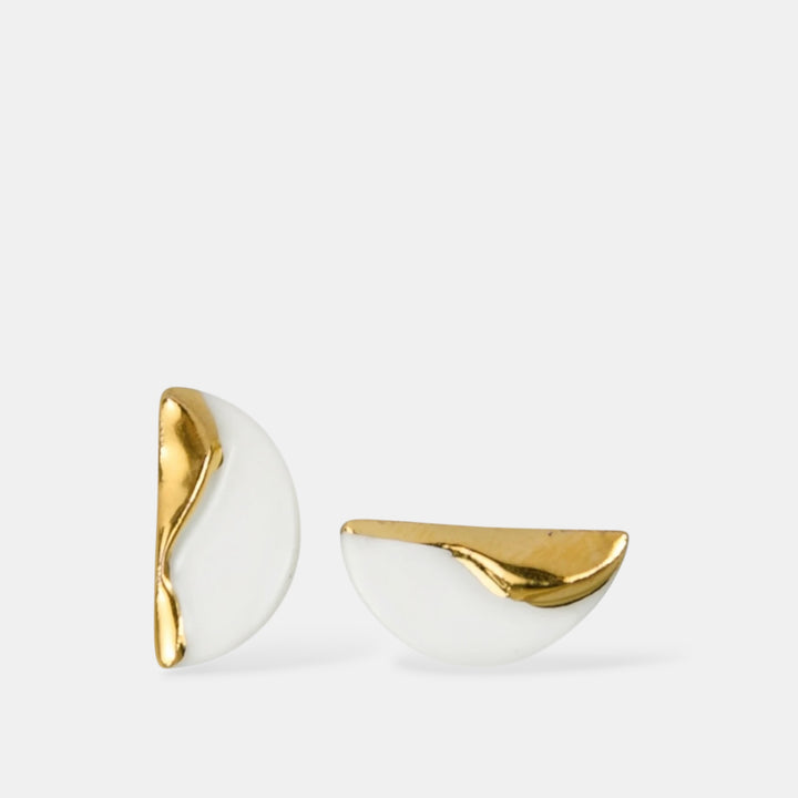 Pair of porcelain earrings with gold and white design on a light gray background by freakyfoxx