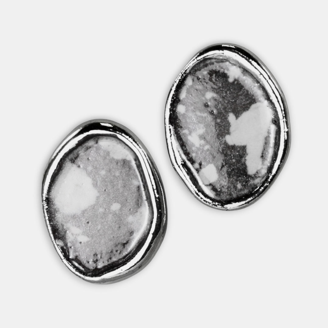 Pair of porcelain earrings with textured design on a white background by FreakyFoxx