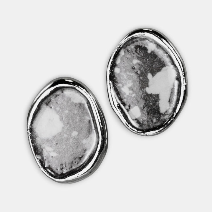 Pair of porcelain earrings with textured design on a white background by FreakyFoxx