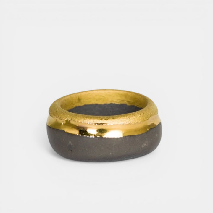 Gold and gray porcelain ring on a light gray background