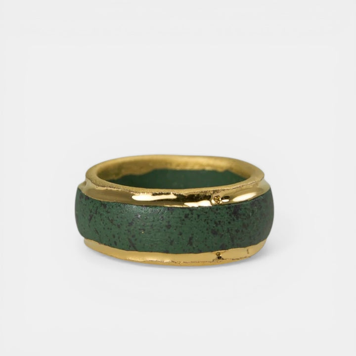 Green ceramic ring with gold band by freakyfoxx on a white background