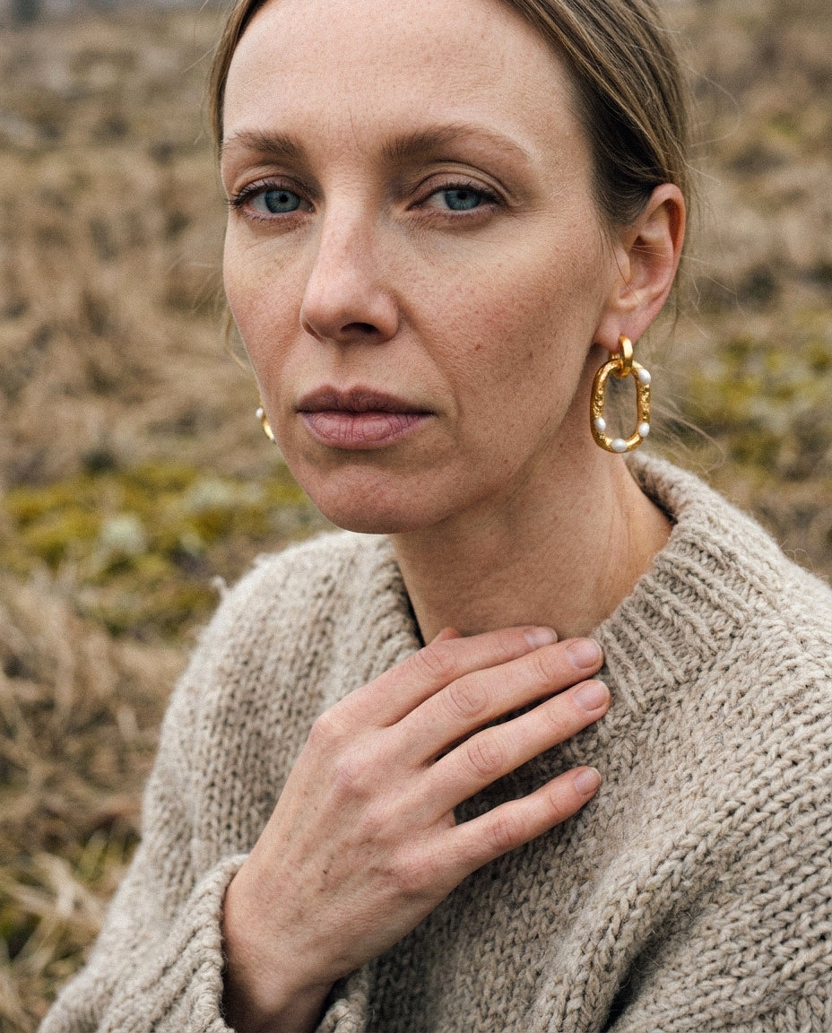 Woman wearing gold hoop earrings  by freakyfoxx in a natural setting