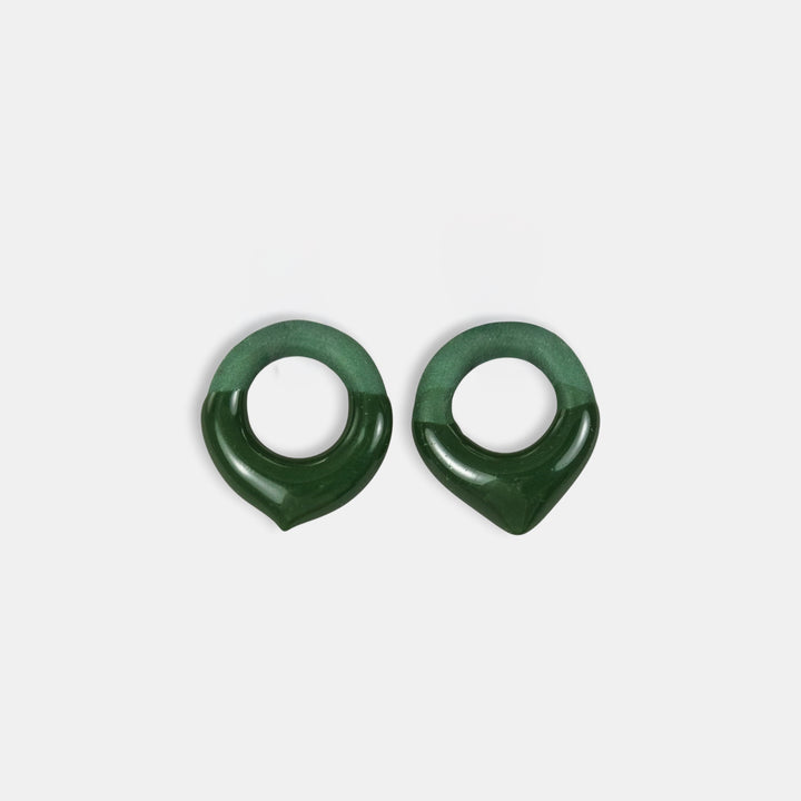 Pair of green earrings on a light gray background