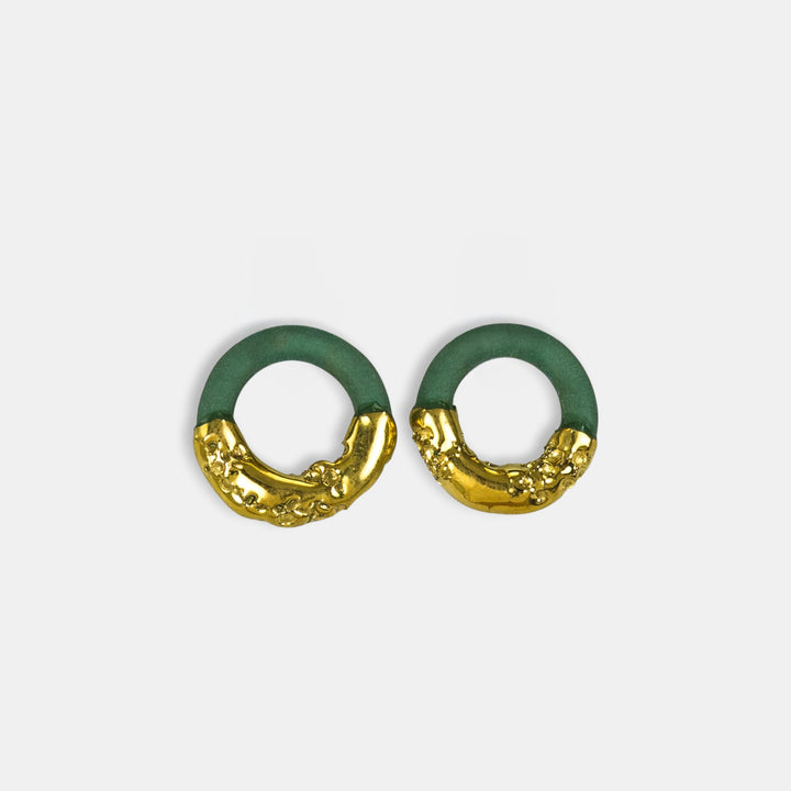 Pora žalių ir auksinių pakabukų auskarams su žiedais baltame fone