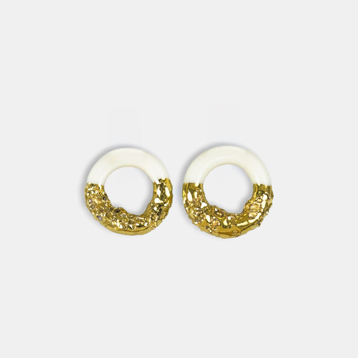 Pair of earrings with gold and white design on a light gray background