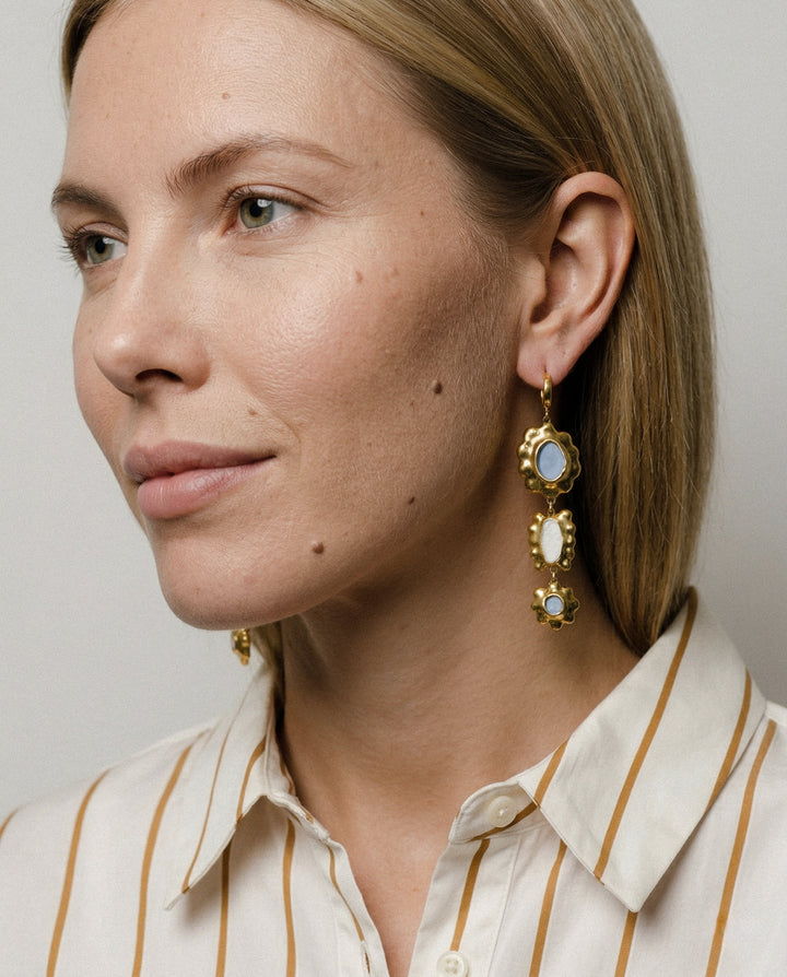 Close-up of a woman unique floral porcelain earrings with a neutral background