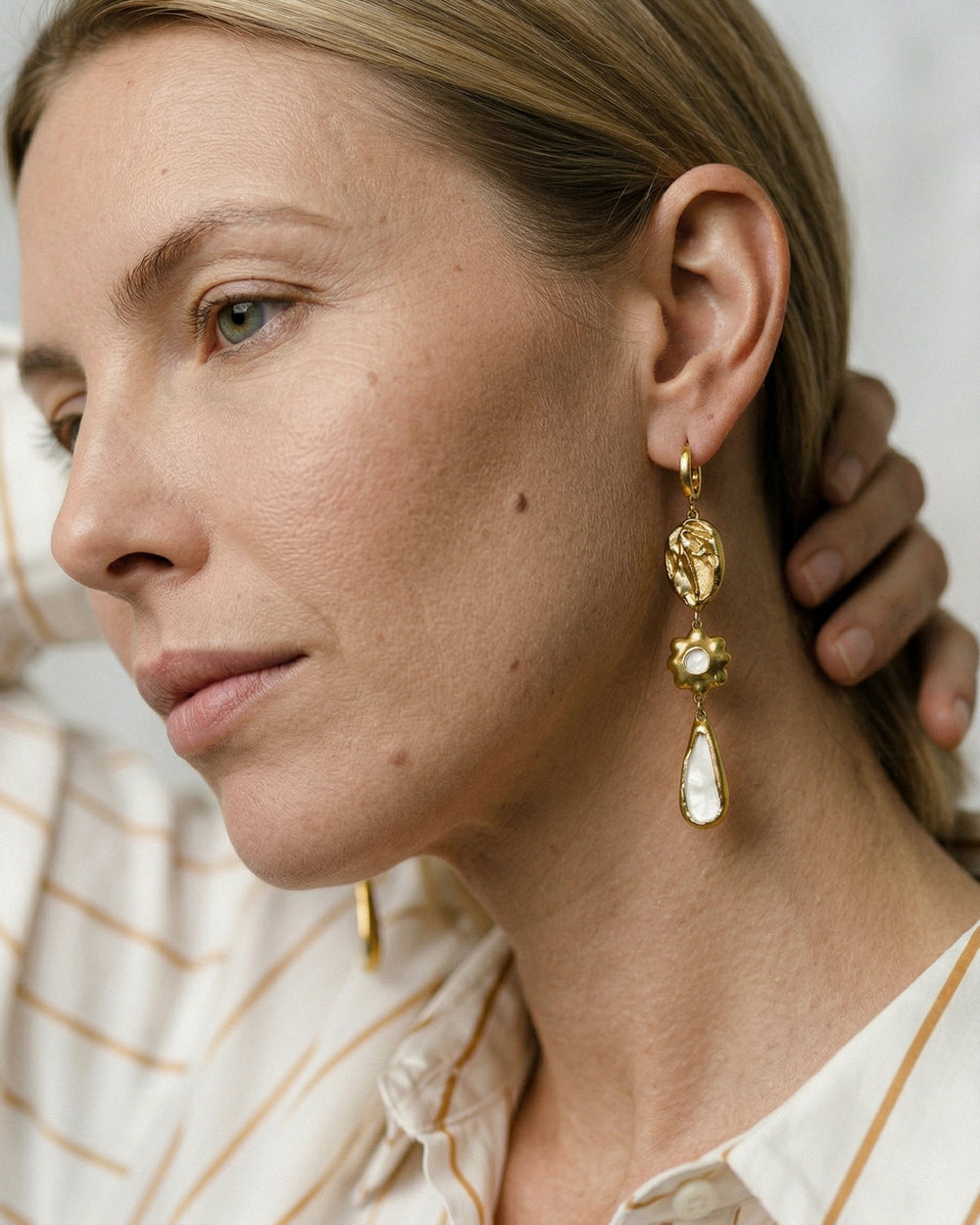 Unikalūs moteriški porcelianiniai auskarai su gėlių raštu neutraliame fone iš arti