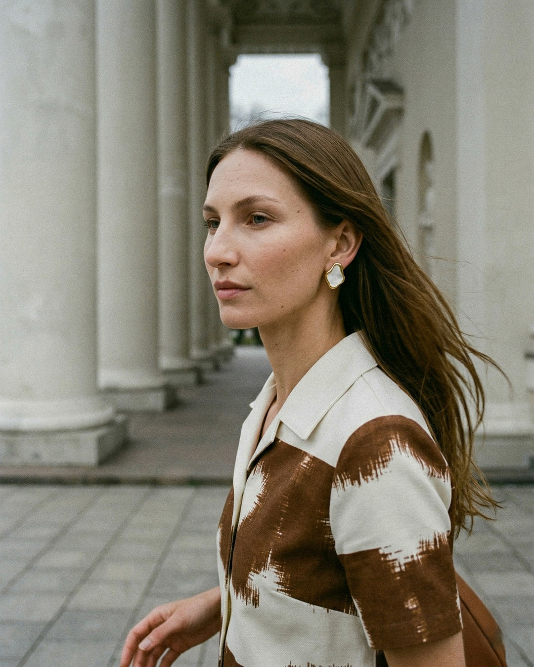 woman wearing handmade porcelain earrings with gold by freakyfoxx in Vilnius