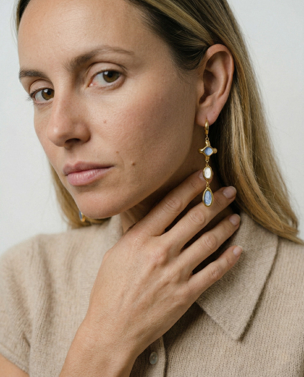 Moteris nešioja rankų darbo porcelianinius auskarus su auksu iš freakyfoxx