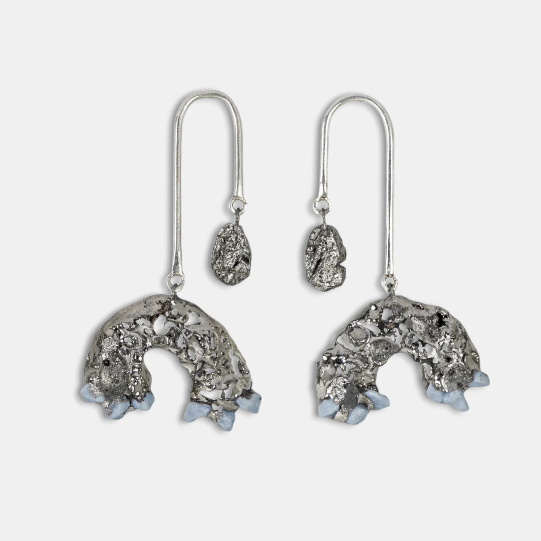 Pair of silver earrings with intricate designs by freakyfixx on a white background