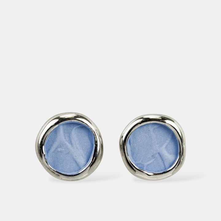 Pair of blue round porcelain earrings with silver rims on a white background by freakyfoxx