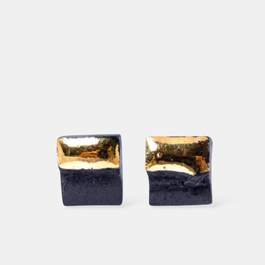Pair of square earrings with gold top and black bottom by freakyfoxx on a white background