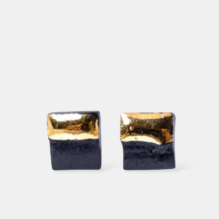 Pair of square earrings with gold top and black bottom by freakyfoxx on a white background