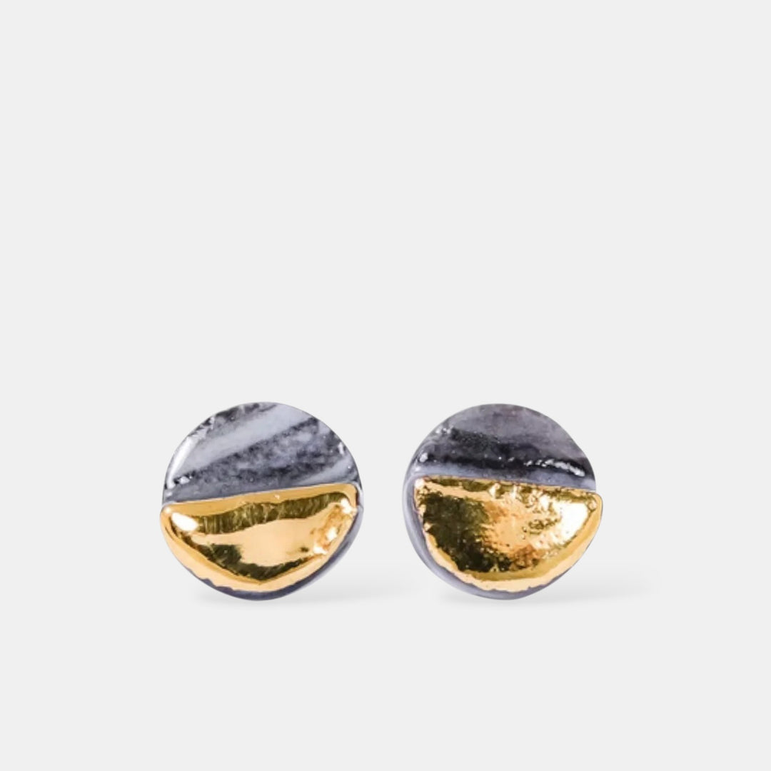 Pair of round earrings with gold and gray marbled design on a white background
