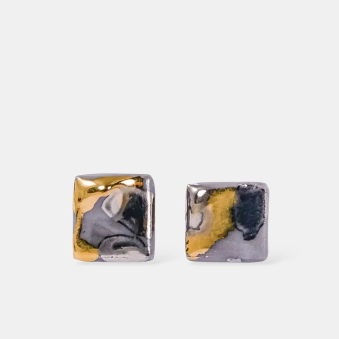 Square-shaped earrings with a metallic finish on a white background