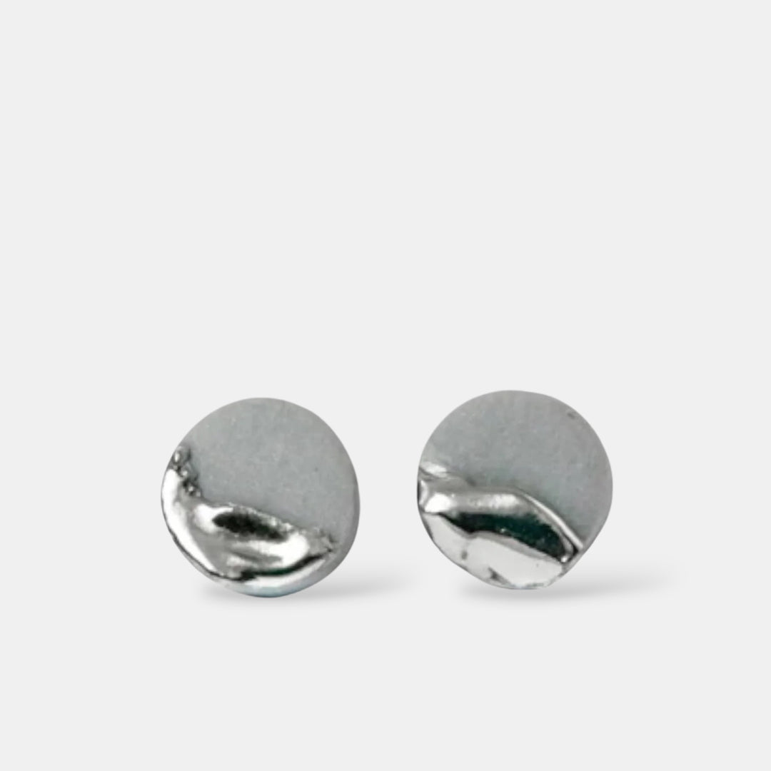 Pair of silver round stud earrings on a light gray background