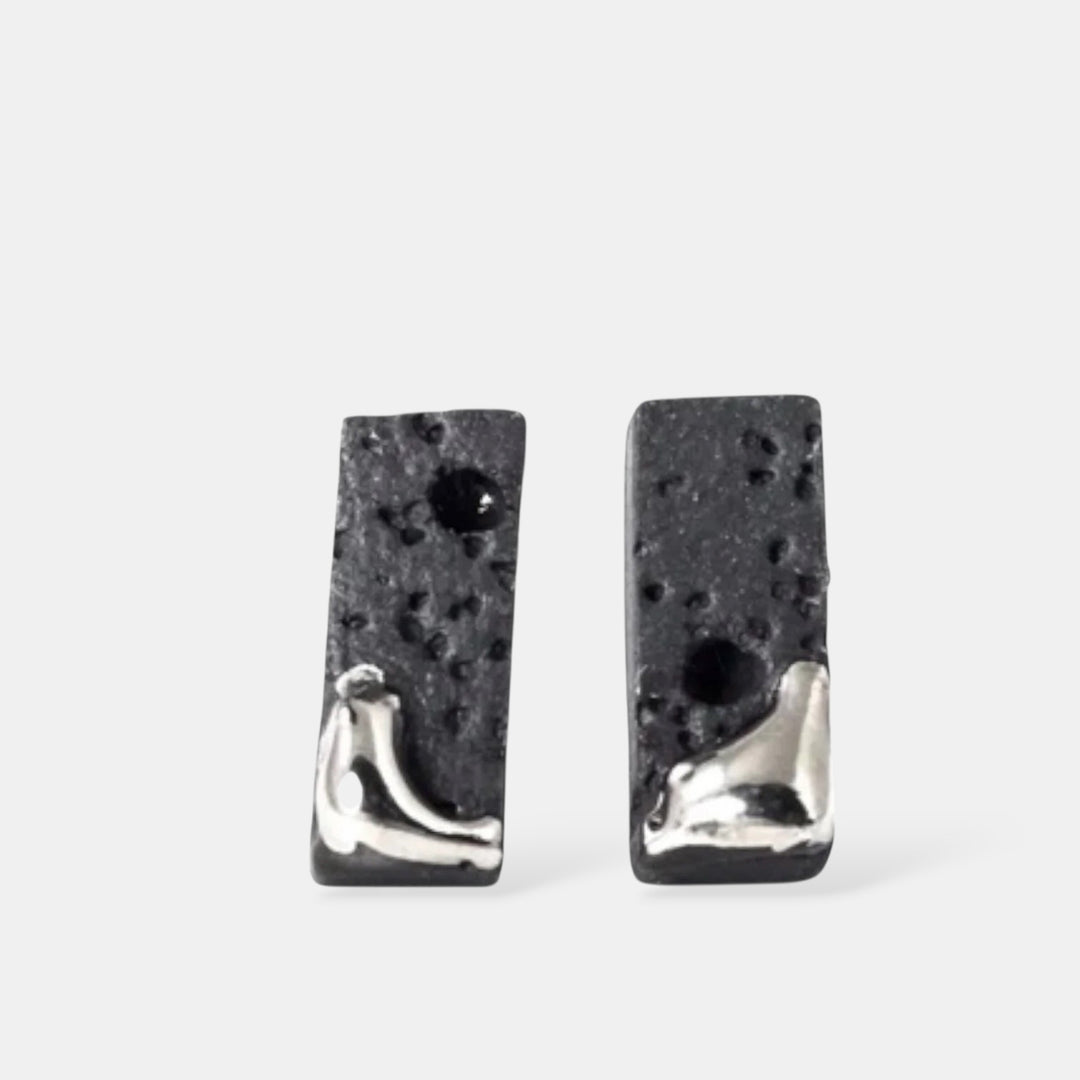 Pair of matte black textured bar earrings with platinum by freakyfoxx on a white background