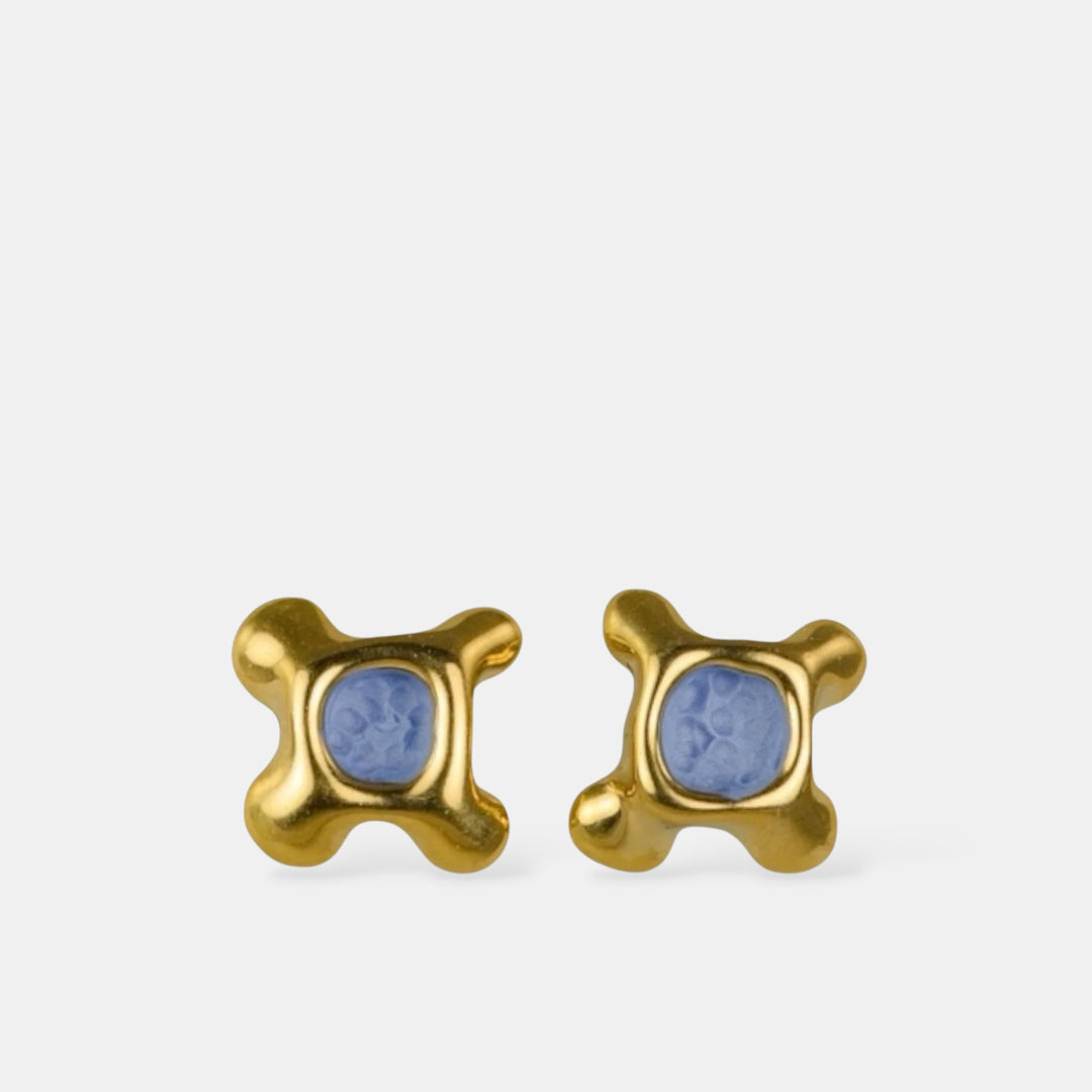 Gold plated porcelain earrings with blue porcelain on a white background