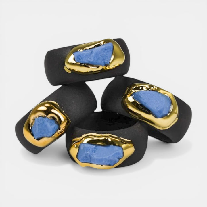 Black rings with gold and blue accents on a white background