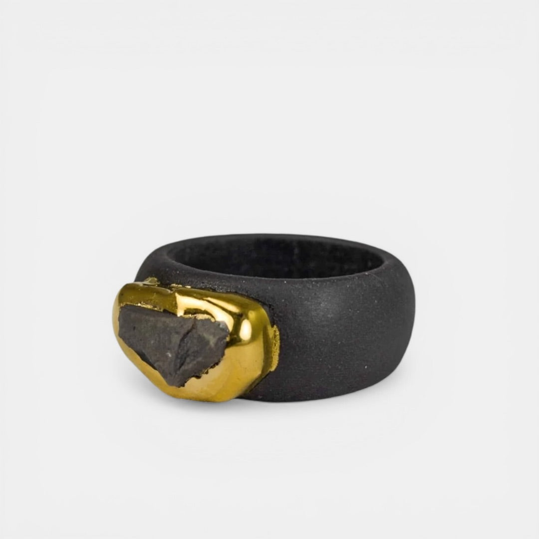 Black porcelain ring with a gold accent on a light gray background
