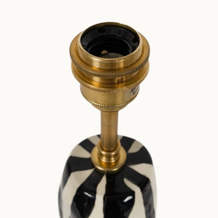 Elegant brass light socket on a glossy ceramic base, ensuring durability and a refined touch.
Elegantiškas žalvarinis šviestuvo lizdas ant blizgaus keraminio pagrindo – užtikrinantis patvarumą ir rafinuotą išvaizdą.