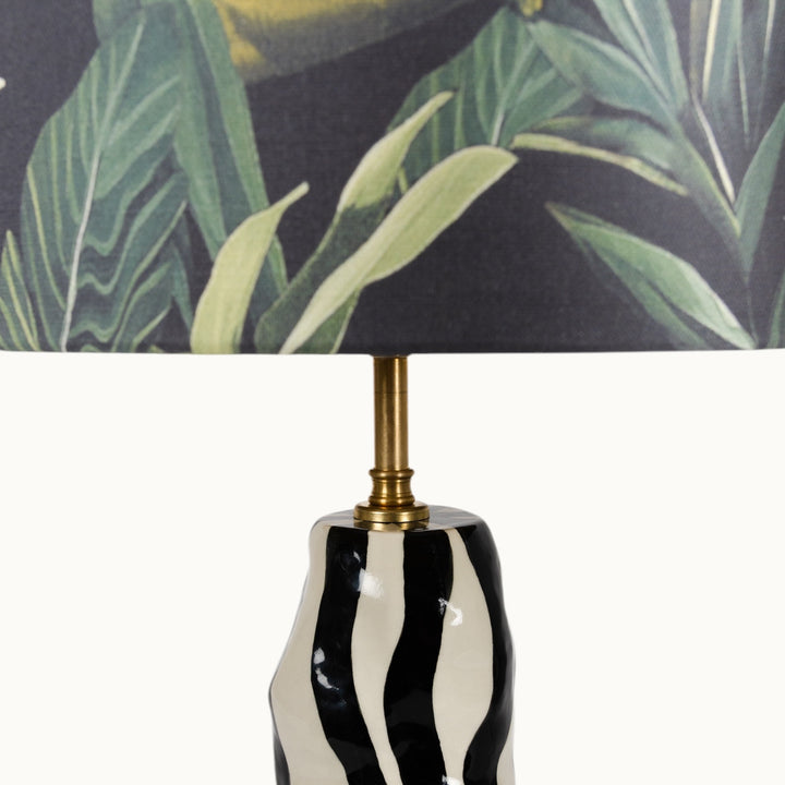 Close-up of the jungle-themed lampshade with lush green leaves, adding a nature-inspired touch to interiors.
Džiunglių tematikos šviestuvo gaubtas su sodriais žaliais lapais – suteikiantis interjerui gamtos įkvėptą akcentą.