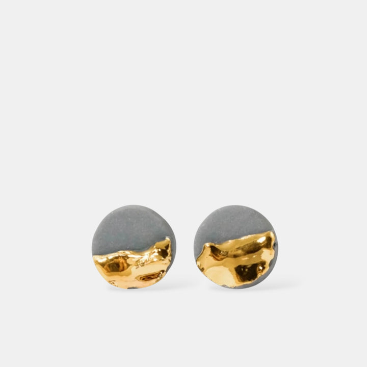 Pair of earrings with gray and gold round design on a white background