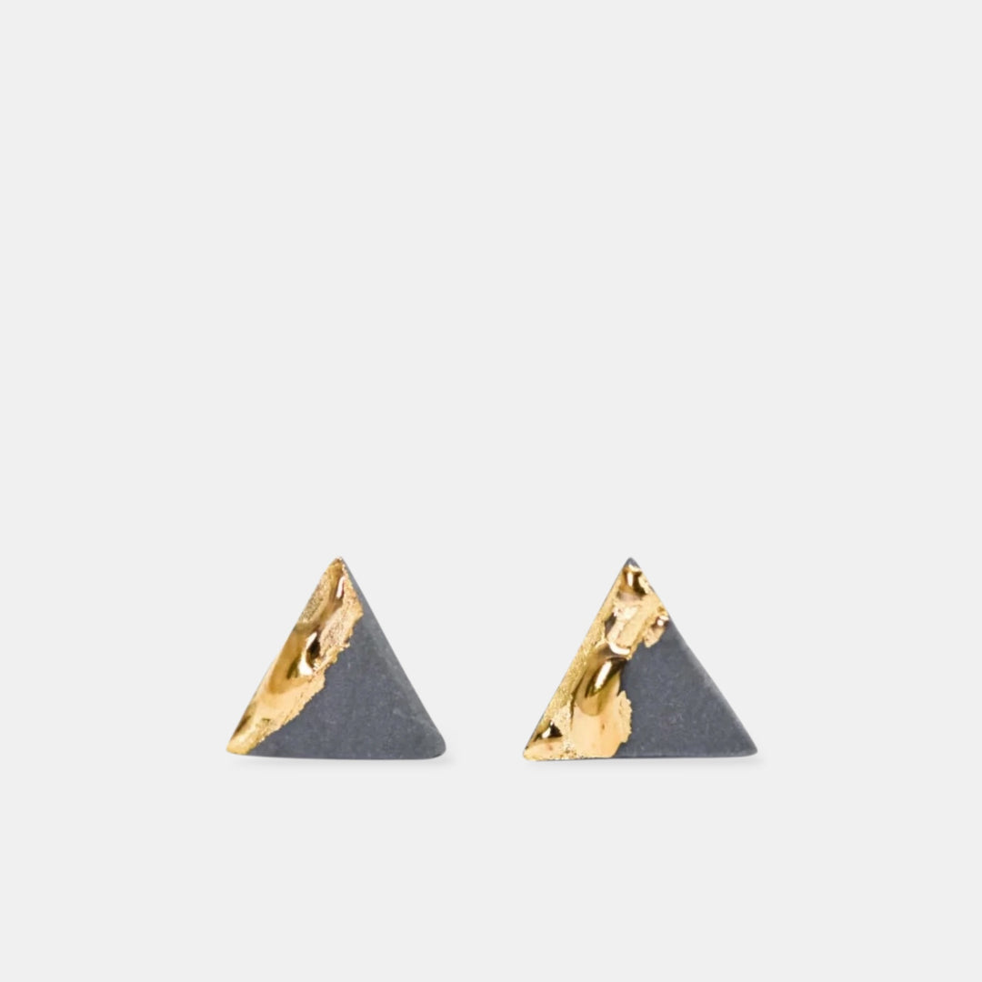 Pair of triangle-shaped earrings with gold and matte gray finish by freakyfoxx on a white background