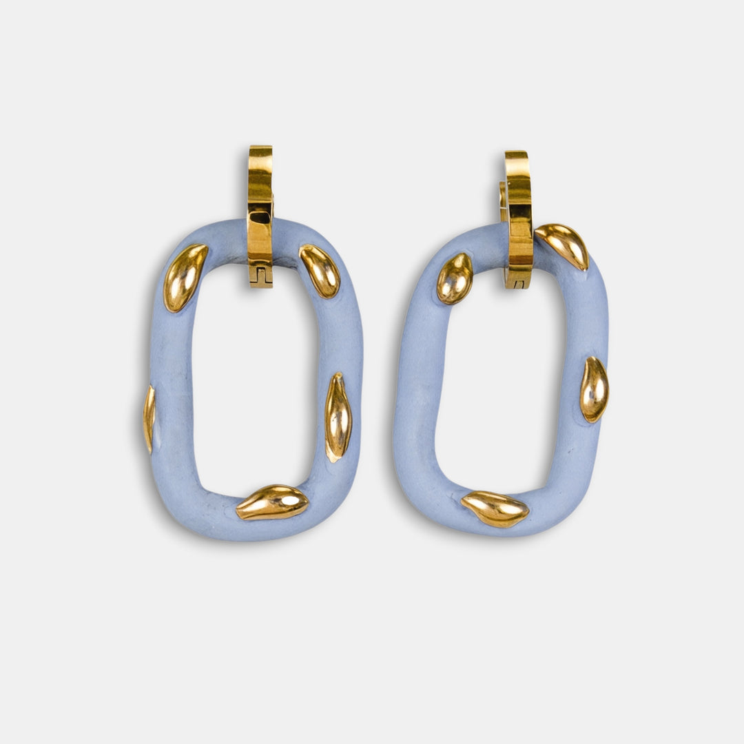 Pora unikalių šviesiai mėlynų lengvų žiedinių auskarų su auksiniais akcentais baltame fone