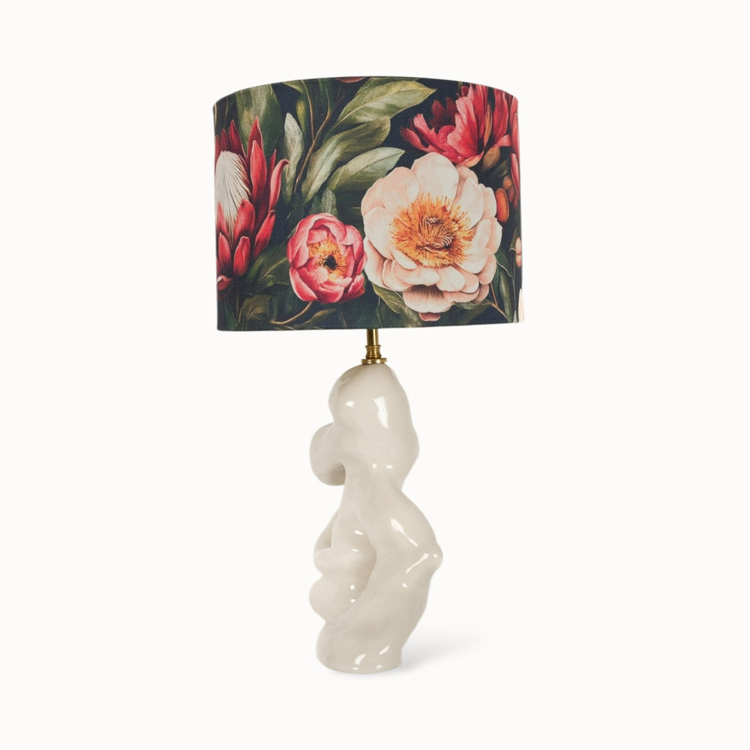 Artistic table lamp with a unique ceramic base and floral lampshade. Perfect for living rooms, bedrooms, and contemporary interiors