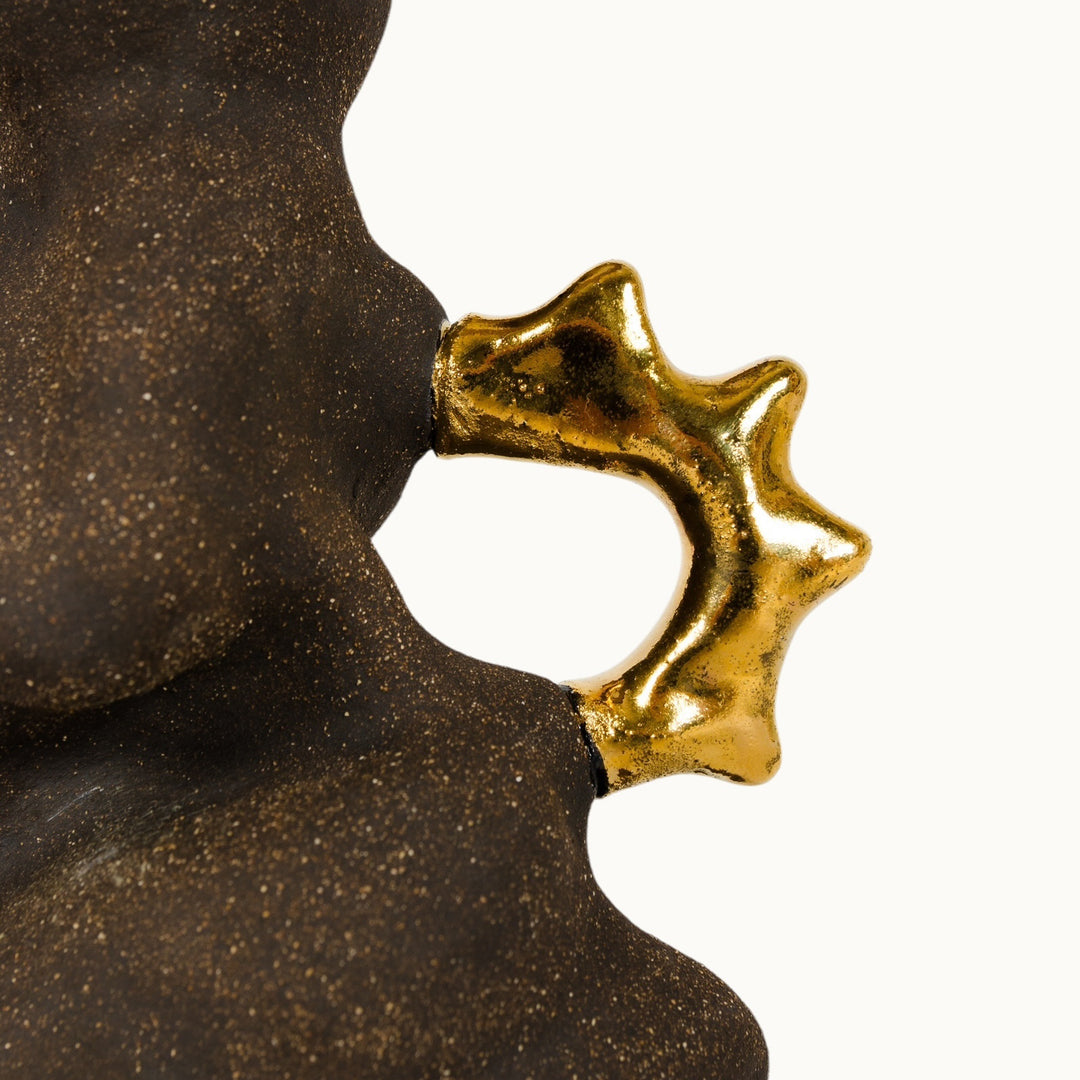 Close-up of gold-plated ceramic handle, adding a unique sculptural element to the lamp base.
Auksu dengta keraminė rankena iš arti – suteikianti šviestuvo pagrindui išskirtinį skulptūrinį elementą.