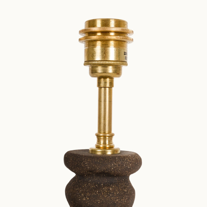 Elegant brass light socket on a textured ceramic lamp base, blending industrial and artistic design.
Elegantiškas žalvarinis šviestuvo lizdas ant tekstūrinio keraminio pagrindo – jungiantis industrinį ir meninį dizainą.