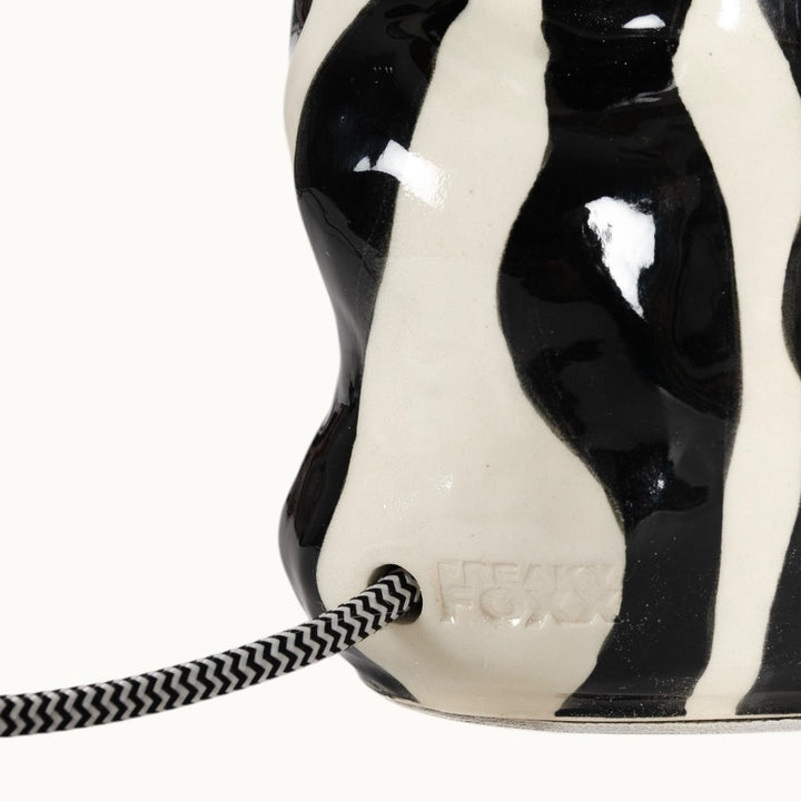 Close-up of the sculptural ceramic base, highlighting its smooth glaze and organic curves.
Keraminio šviestuvo pagrindo stambus planas – išryškinantis jo švelnią glazūrą ir organiškas linijas.