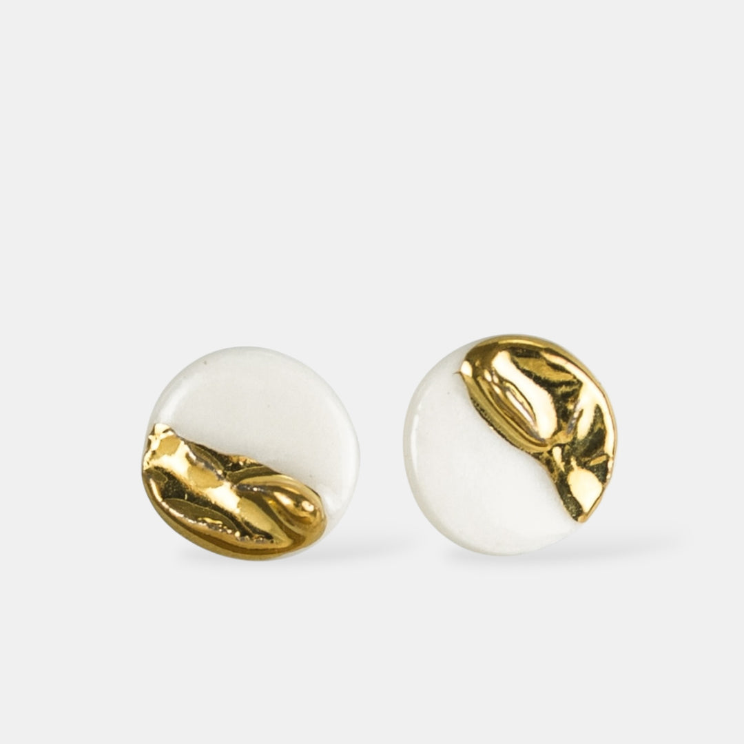 Pair of porcelain earrings with gold and white design by freakyfoxx on a light gray background