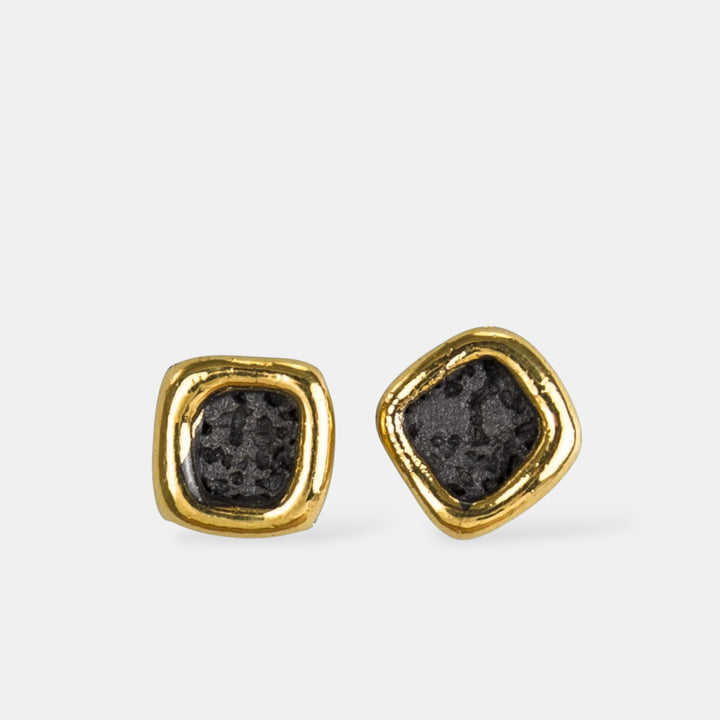 Gold-framed black porcelain stud earrings on a light gray background