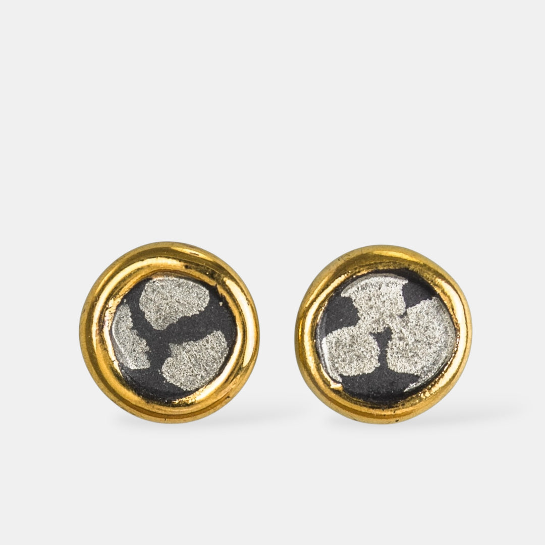 Apvalių auskarų pora su auksiniais apvadais ir juodu porcelianu baltame fone