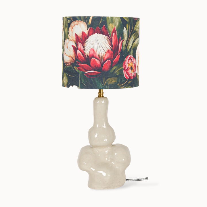 Handcrafted stoneware table lamp with a sculptural base and a floral linen lampshade, creating a bold artistic statement.
Rankų darbo akmens masės stalo šviestuvas su skulptūriniu pagrindu ir gėlių rašto lininio audinio gaubtu – išskirtinis meninis akcentas.