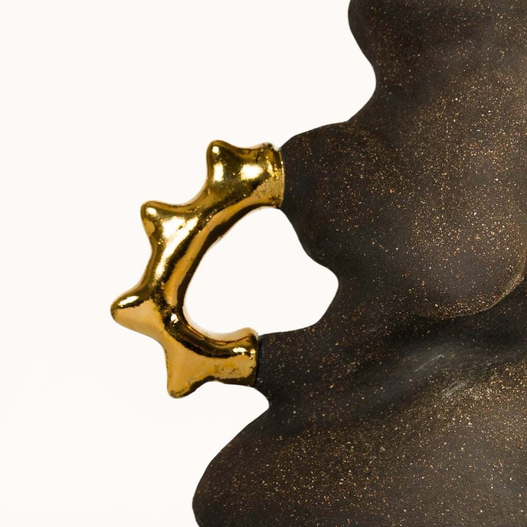 Textured stoneware lamp base with gold-plated organic handles, inspired by natural forms.
 akmens masės šviestuvo pagrindas su auksu dengtomis organiškomis rankenomis – įkvėptas gamtos formų.